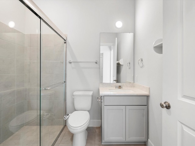 bathroom with toilet, vanity, tile patterned floors, and a shower with door