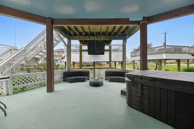 view of patio featuring a deck with water view and an outdoor living space with a fire pit