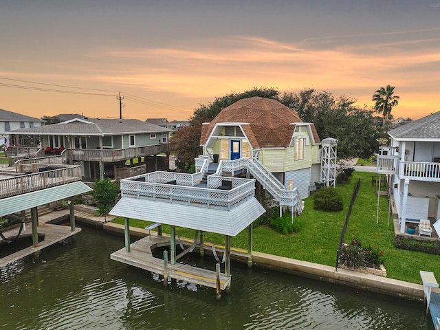 view of dock with a yard and a water view