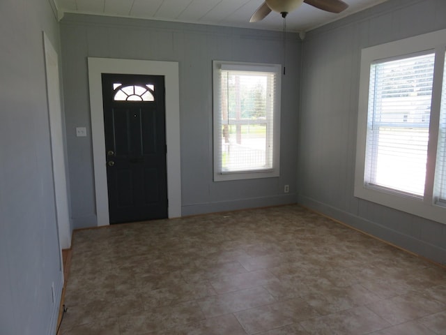 entrance foyer with ceiling fan and crown molding