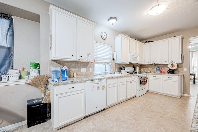 kitchen featuring sink, white cabinets, and white appliances