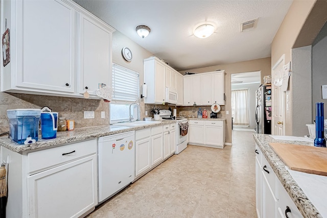 kitchen with white cabinetry, sink, white appliances, and backsplash