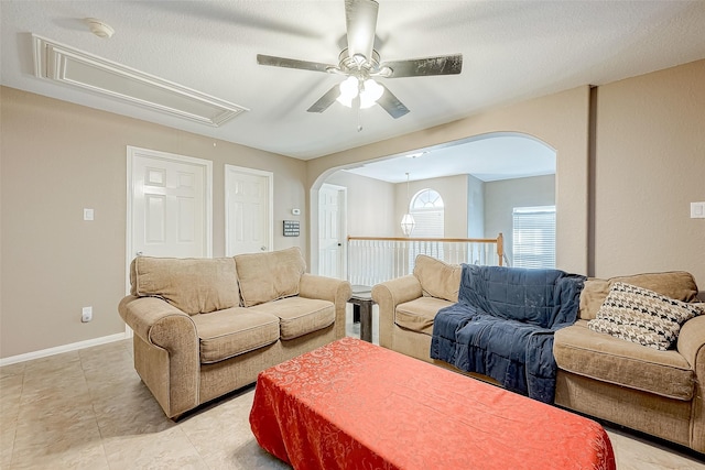 living room with ceiling fan, light tile patterned floors, and a textured ceiling