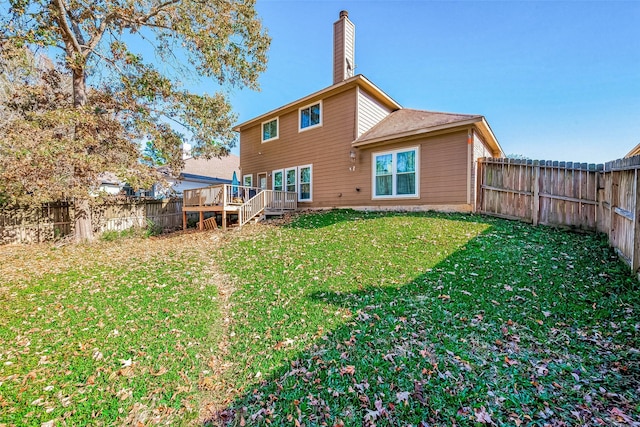 rear view of property with a lawn and a wooden deck