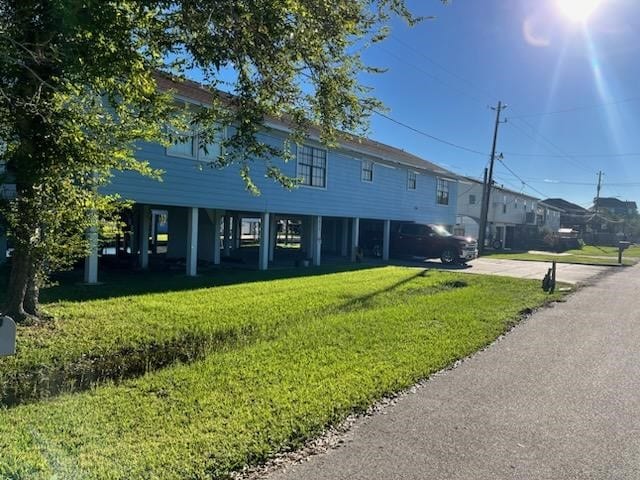 exterior space with a carport and a front lawn