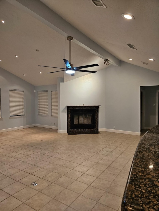 unfurnished living room with a fireplace, light tile patterned floors, lofted ceiling with beams, and ceiling fan