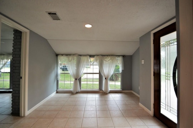 tiled foyer entrance with a textured ceiling