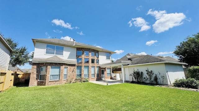 rear view of property featuring a patio area and a lawn