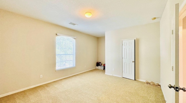 carpeted spare room featuring a textured ceiling