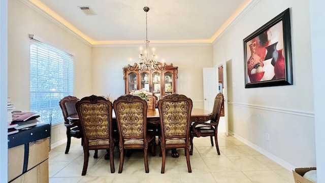 tiled dining area with a healthy amount of sunlight, ornamental molding, and an inviting chandelier