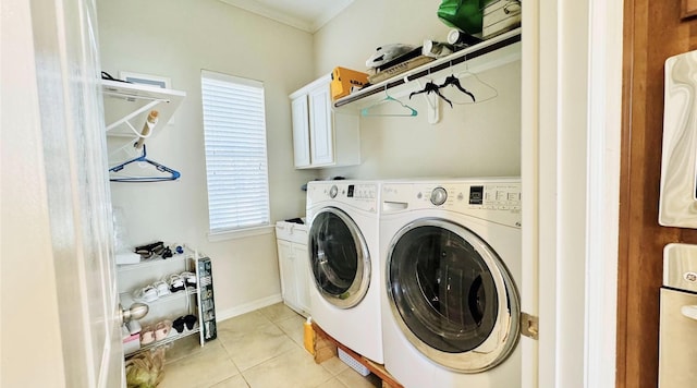 laundry area with washing machine and dryer, light tile patterned floors, and cabinets