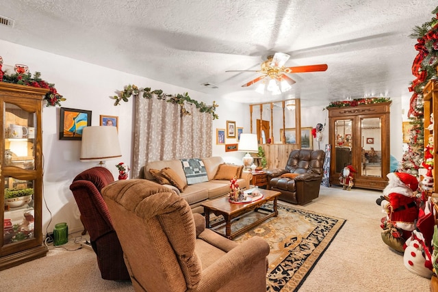 living room with a textured ceiling, light colored carpet, and ceiling fan