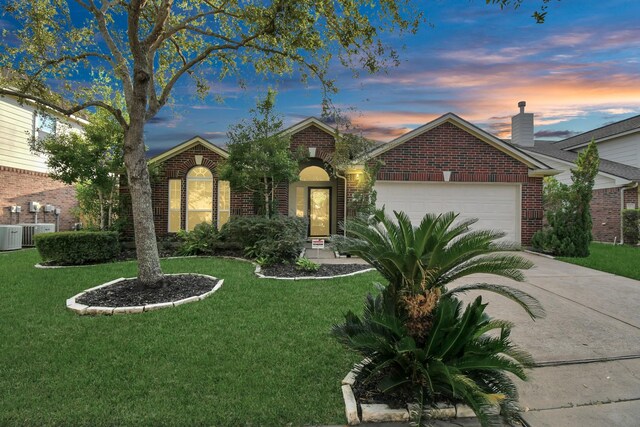 single story home featuring a garage and a yard