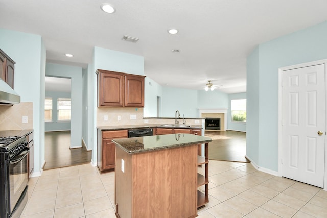 kitchen with ceiling fan, sink, dark stone counters, decorative backsplash, and black appliances