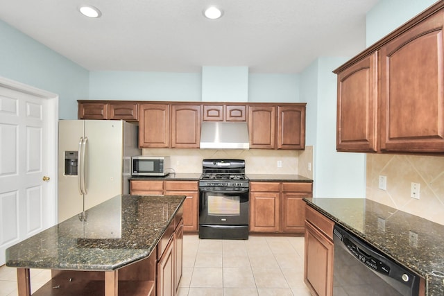 kitchen featuring appliances with stainless steel finishes, ventilation hood, dark stone countertops, a kitchen island, and light tile patterned flooring