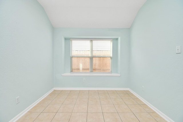 tiled spare room with lofted ceiling