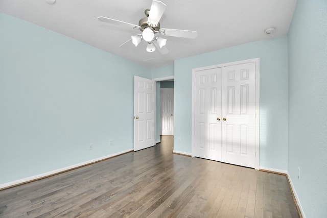 unfurnished bedroom featuring ceiling fan, dark hardwood / wood-style flooring, and a closet