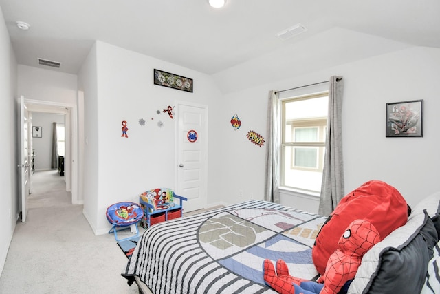 bedroom with light colored carpet and lofted ceiling