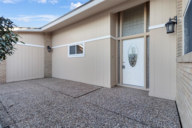 view of exterior entry with a patio