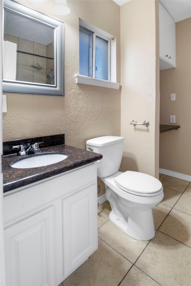 bathroom featuring tile patterned flooring, vanity, and toilet