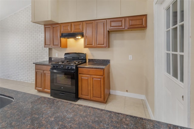 kitchen with black range with gas cooktop, brick wall, and light tile patterned floors