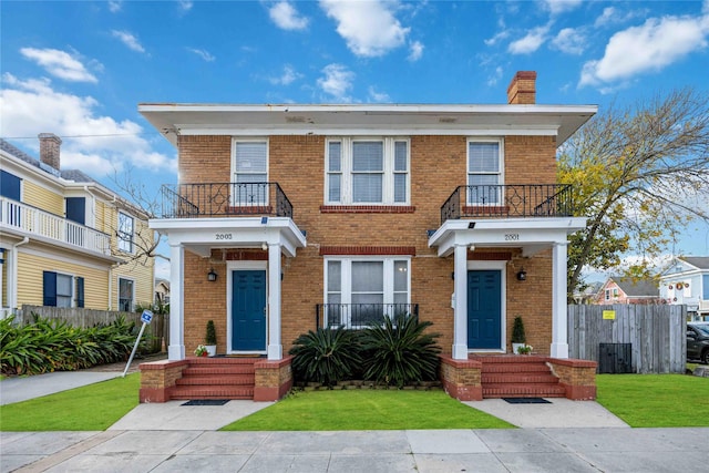 view of front of home with a balcony and a front yard