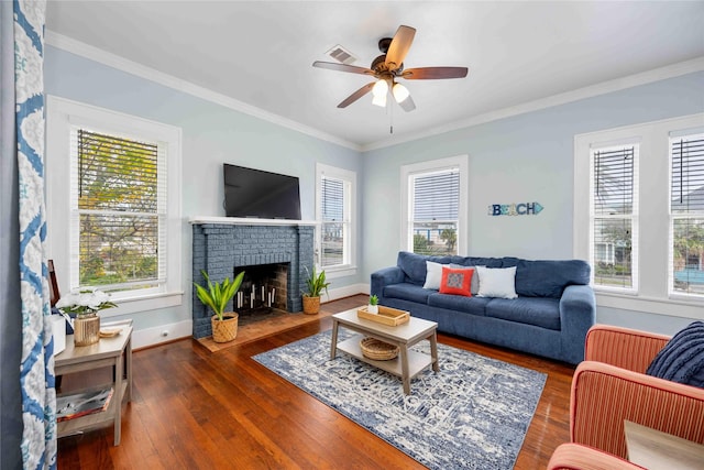 living room with a healthy amount of sunlight, ornamental molding, and dark wood-type flooring