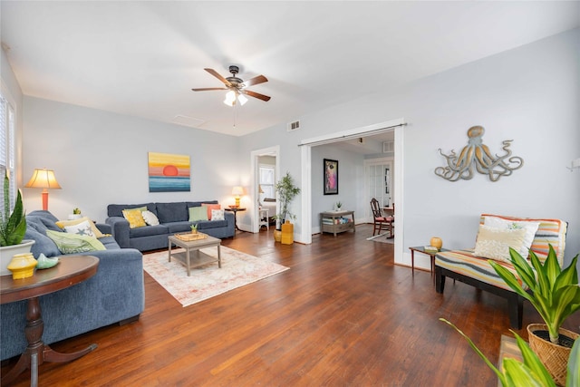 living room featuring ceiling fan and dark hardwood / wood-style floors