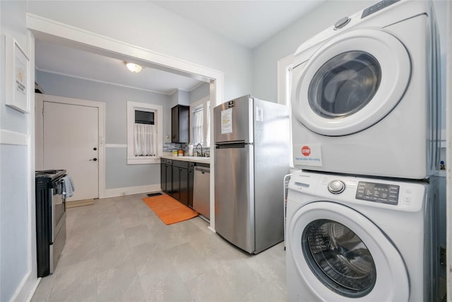 washroom featuring stacked washer / dryer and sink