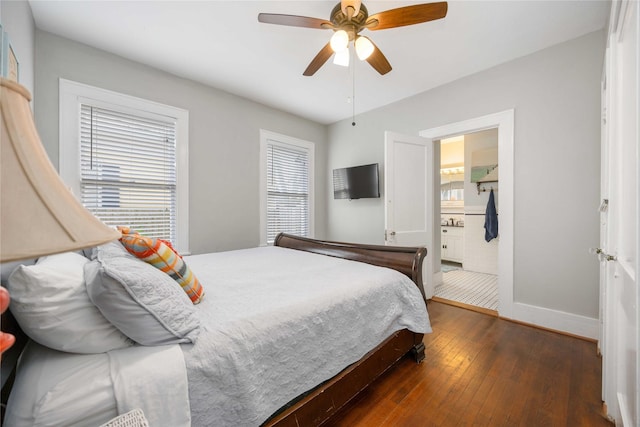 bedroom featuring multiple windows, ceiling fan, ensuite bath, and dark wood-type flooring