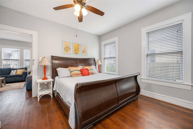 bedroom featuring dark hardwood / wood-style floors, multiple windows, and ceiling fan