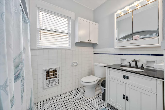 bathroom featuring vanity, tile patterned floors, toilet, tile walls, and heating unit