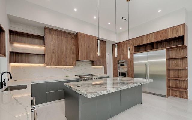 kitchen with sink, hanging light fixtures, decorative backsplash, a kitchen island, and appliances with stainless steel finishes