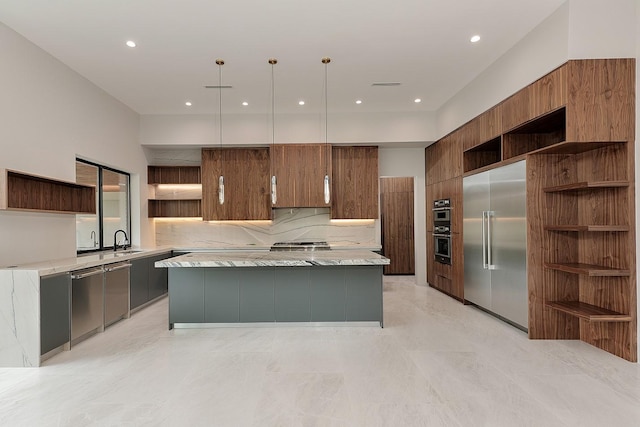 kitchen featuring appliances with stainless steel finishes, tasteful backsplash, sink, a center island, and hanging light fixtures