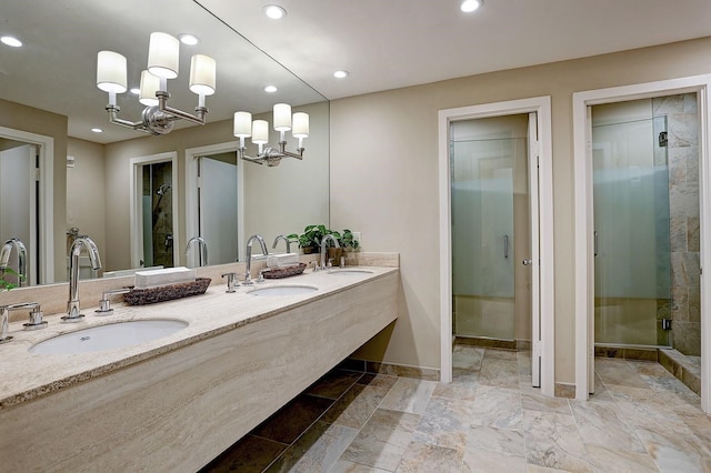 bathroom with vanity, a shower with door, and a notable chandelier