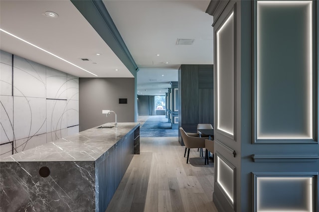 hallway with hardwood / wood-style flooring and sink