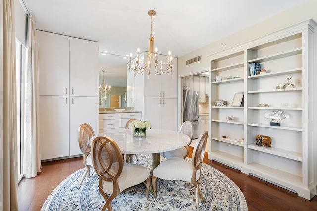 dining room featuring dark hardwood / wood-style floors and an inviting chandelier