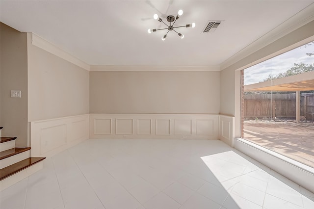 empty room featuring ornamental molding and a chandelier