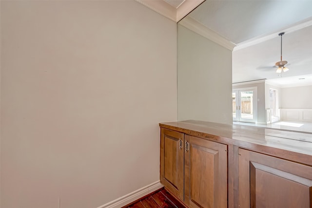 interior space with ceiling fan, dark hardwood / wood-style flooring, and ornamental molding