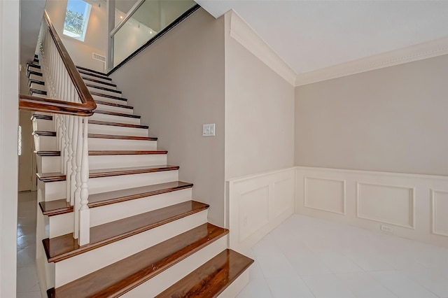 stairs featuring crown molding and a skylight