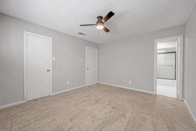 carpeted spare room featuring ceiling fan and a textured ceiling