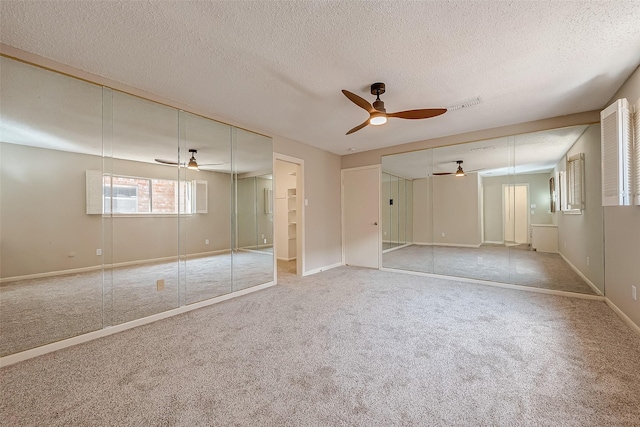 unfurnished bedroom featuring a textured ceiling, ceiling fan, and light carpet