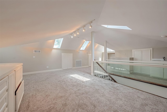 bonus room with lofted ceiling with skylight and light colored carpet