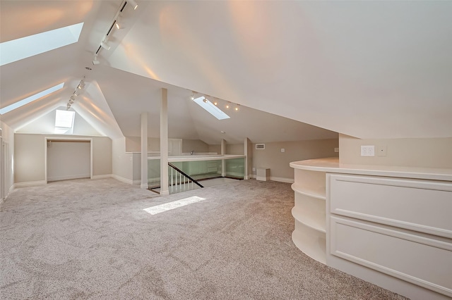 bonus room featuring vaulted ceiling with skylight and light colored carpet