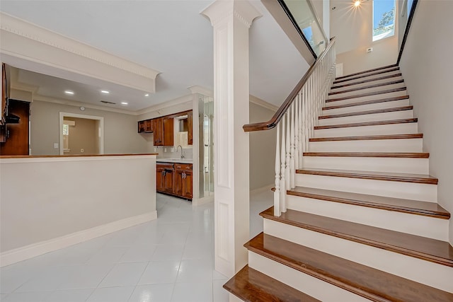 staircase featuring tile patterned floors, sink, and ornamental molding