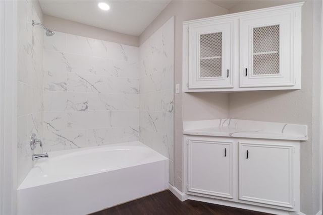 bathroom featuring wood-type flooring and tiled shower / bath