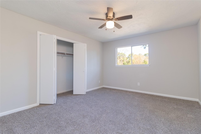 unfurnished bedroom with ceiling fan, a closet, carpet floors, and a textured ceiling