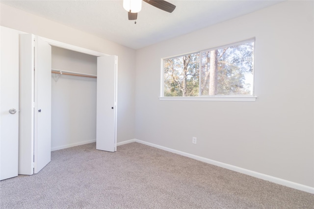 unfurnished bedroom with ceiling fan, light colored carpet, and a closet