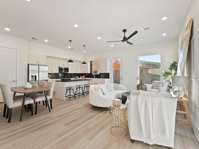 living room featuring ceiling fan and light hardwood / wood-style flooring