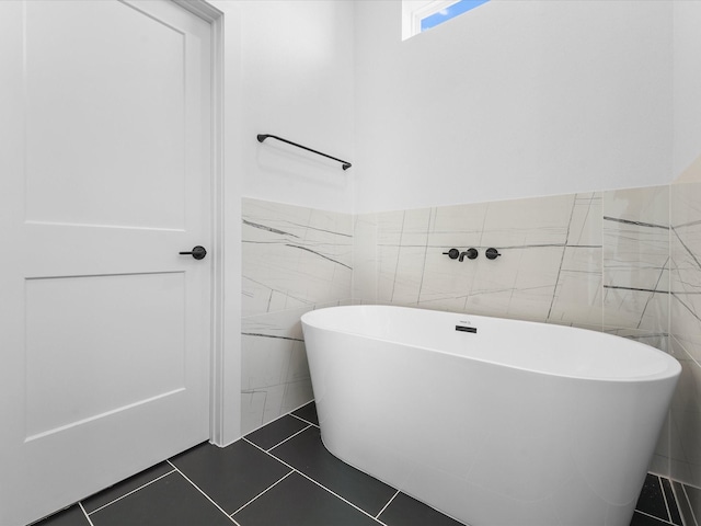 bathroom with tile patterned floors, tile walls, and a tub to relax in